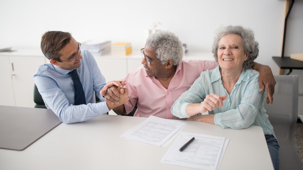 An agent sitting with smiling clients