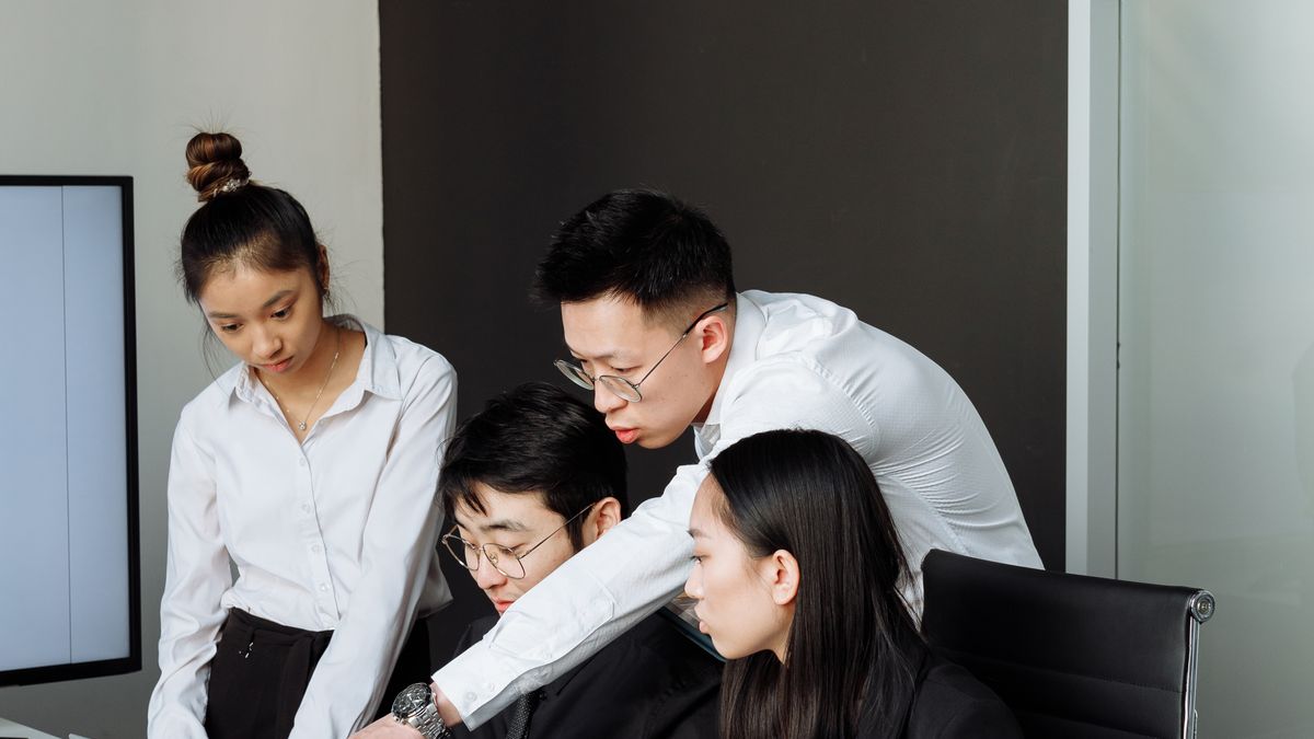 Colleagues reviewing a laptop screen